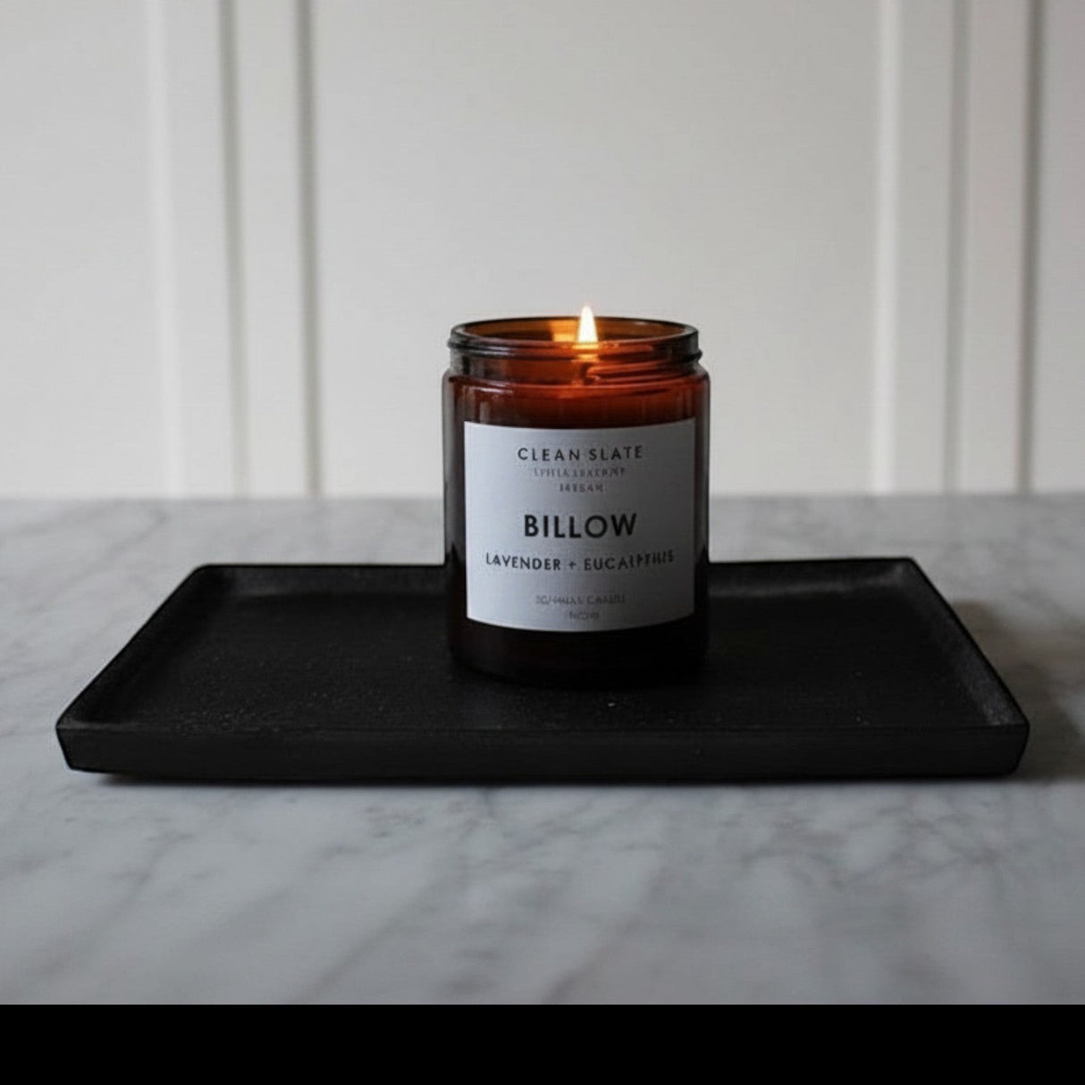 Connemara Country CLEAN SLATE Billow amber glass candle with lavender and eucalyptus scent, lit flame.