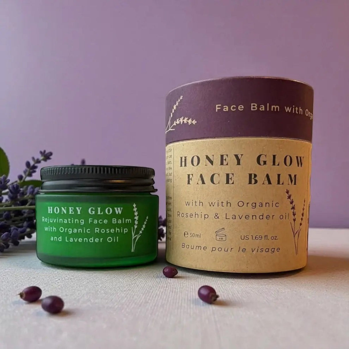Connemara Country Janni Bars Honey Glow face balm in a green glass jar and cardboard tube with lavender sprigs.