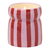 Connemara Country Paddywax Cabana ceramic candle with red and pink vertical stripes and a lit wick