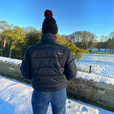 Connemara Country Breeze Up POLAR+ black goose down puffer coat worn by a person in a snowy outdoor setting