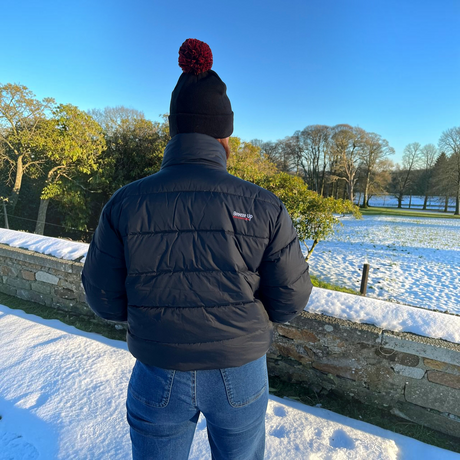 Connemara Country Breeze Up POLAR+ black goose down puffer coat worn by a person in a snowy outdoor setting