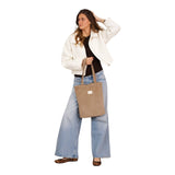 Connemara Country model wearing a beige corduroy zippered tote bag with shoulder straps against a white wall