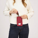 Connemara Country burgundy corduroy glasses case with zipper and beige cord handle held by a woman in a white sweater.