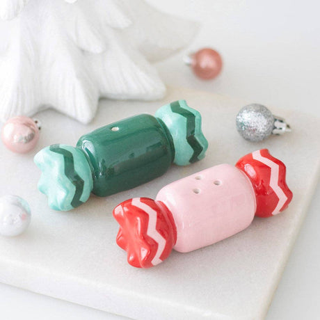 Connemara Country ceramic Christmas sweet-shaped salt and pepper shakers in green and pink on a marble surface.