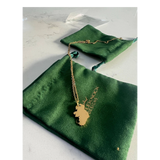 CastleKnock Designs gold Map of Ireland pendant necklace on a delicate chain, presented in a green pouch.