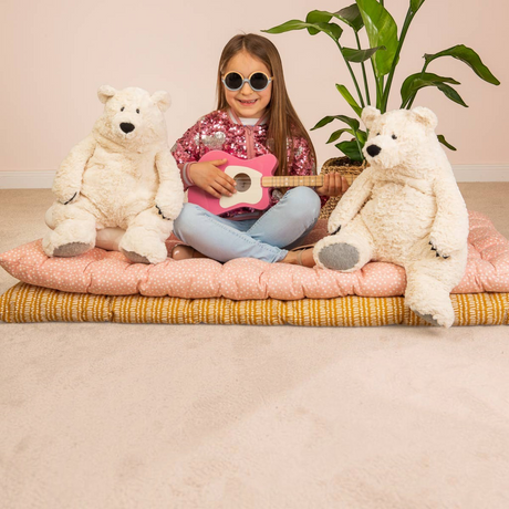 Connemara Country girl playing a toy guitar with two fluffy Teddy Hermann Polar Bear Jones plush toys on cushions.