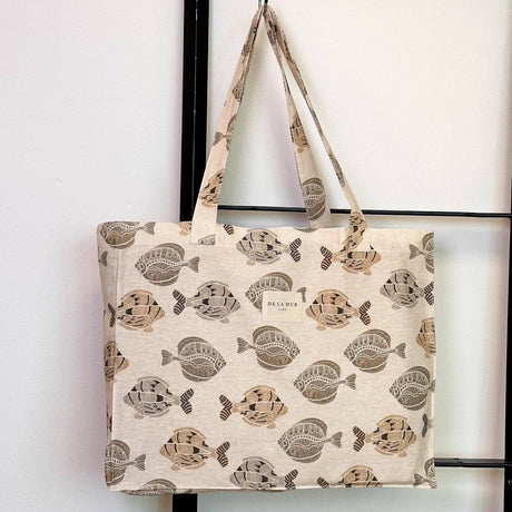 Connemara Country De La Mur rectangular fabric bag in beige with a brown fish print and shoulder straps.