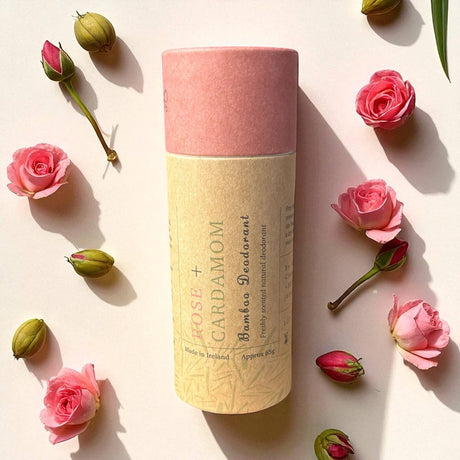 Connemara Country Janni Bars rose and cardamom bamboo deodorant in a plastic-free paper tube surrounded by rose buds.
