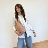 Connemara Country small Greek tote bag in terracotta jacquard fabric with geometric print, worn by a smiling woman.